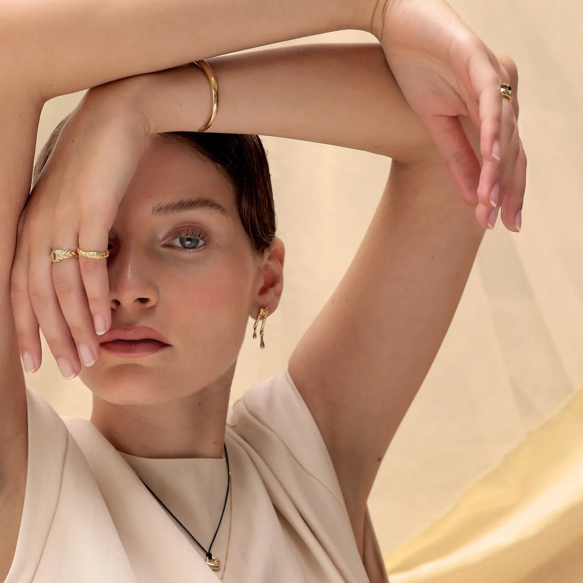 Model trägt Melted Halskette, Ringe und Ohrringe ing gold plattiert | Elli